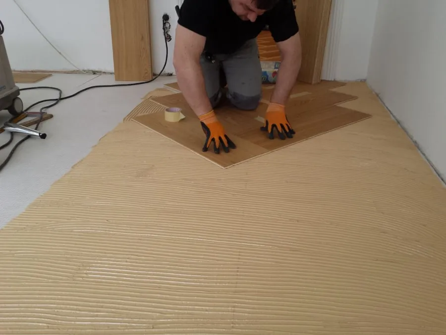 Bodenleger verlegt Dielen auf einem vorbereiteten Untergrund